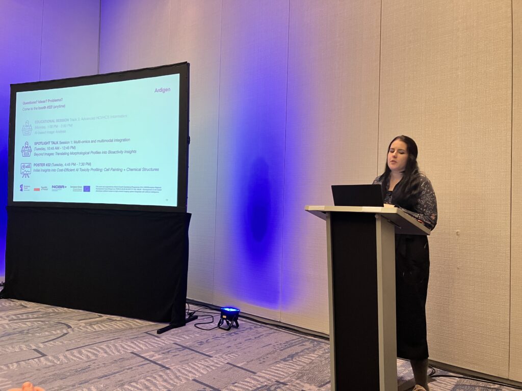 Speaker presenting during an educational session on AI-based high-content imaging workflows at the SBI² 2025 conference.