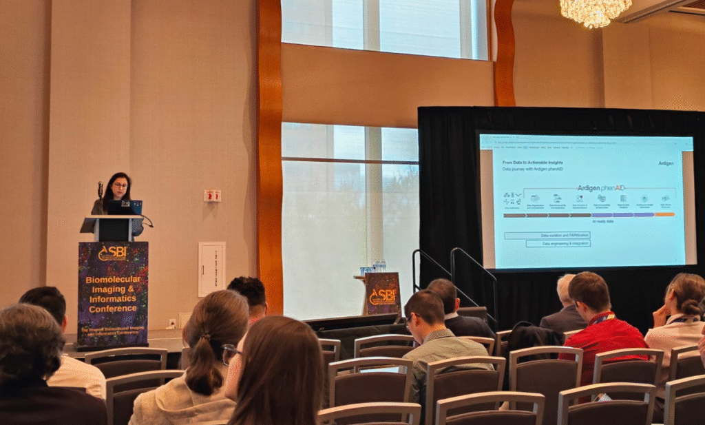 Speaker presenting research slide to an audience during the SBI² 2025 conference session on imaging and phenotypic profiling.