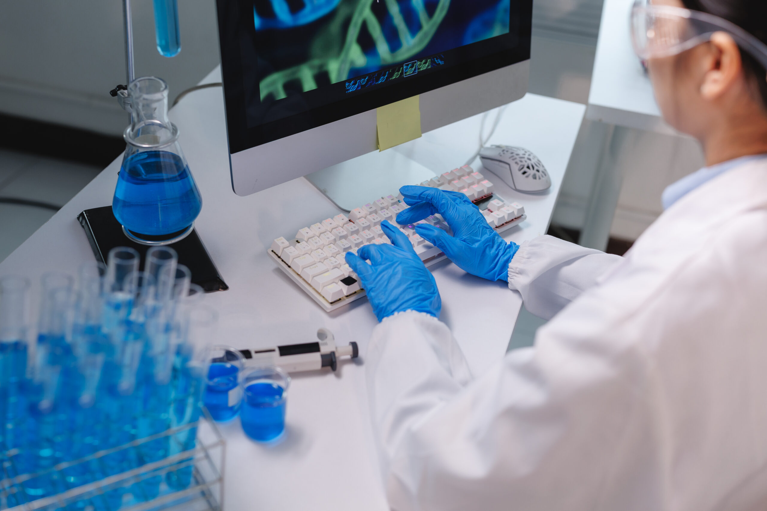 Lab Researcher Typing DNA Findings into Computer